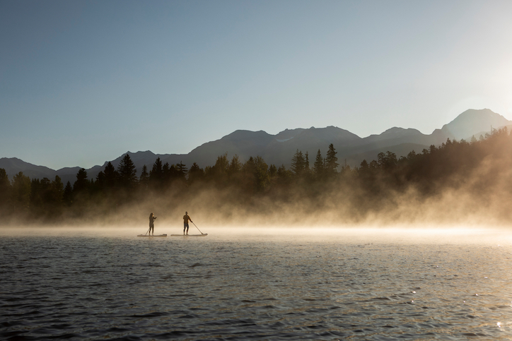 two people on paddleboards on whistler lake bc canada