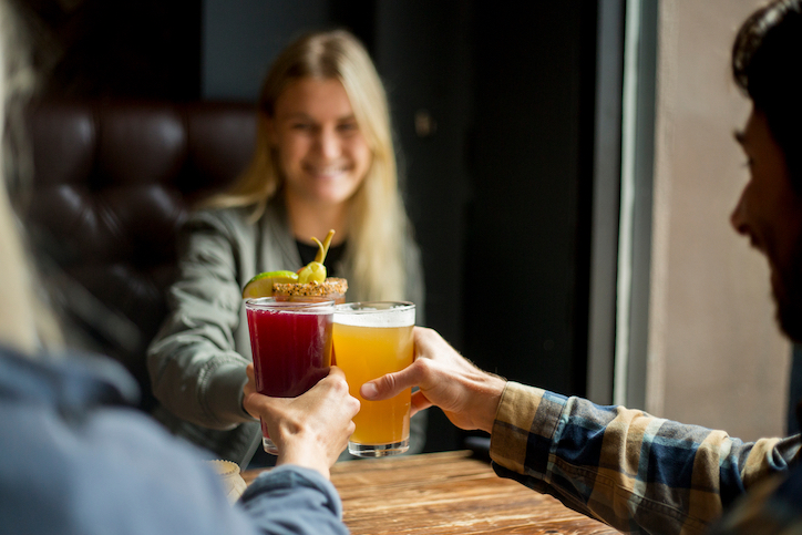 three friends at restaurant cheersing drinks