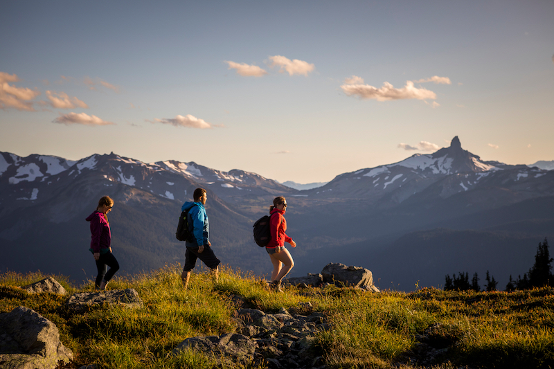 three people hiking along the ridge at whistler blackcomb in british columbia canada