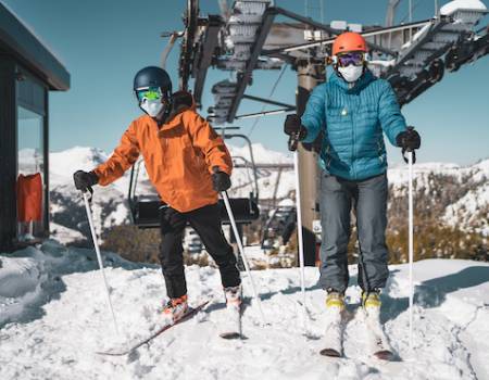 Skiers get off of a ski lift