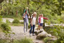 Family of 5 hiking on a path by a river